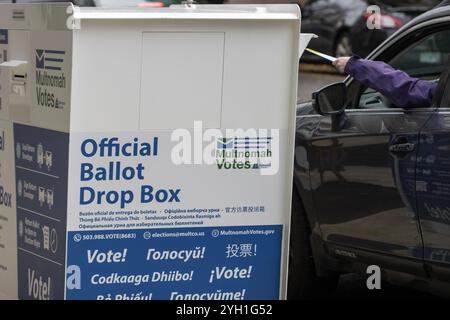 Die Wähler geben ihre Stimmzettel an einer Wahlbox vor der Multnomah County Wahlabteilung ab, einer Wählerregistrierungsstelle in Portland... Stockfoto