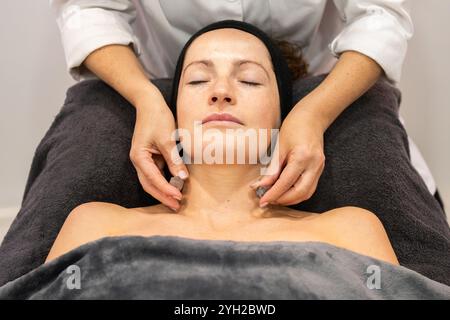 Frau erhält Nackenhautbehandlung im Schönheitssalon Stockfoto