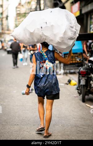 Ein philippinischer Marktarbeiter trägt seine Waren auf einem Markt in China Town, Binondo District, Manila, den Philippinen. Stockfoto