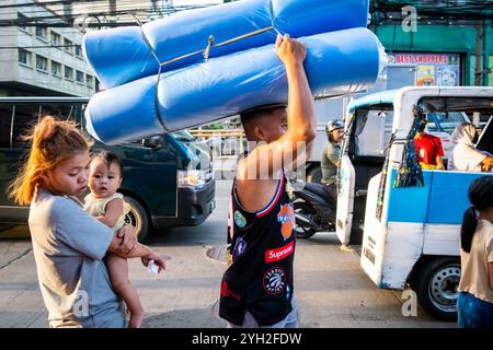 Ein philippinischer Marktarbeiter trägt seine Waren auf einem Markt in China Town, Binondo District, Manila, den Philippinen. Stockfoto