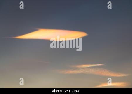 Eine sehr seltene schillernde Wolke bei Sonnenuntergang an einem Wintertag Stockfoto