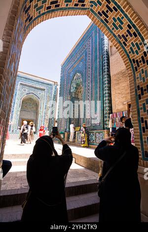 Samarkand, Usbekistan - 6. Juli 2024: Zwei weibliche Touristen machen Fotos an den Portalen der Mausoleen in Shah-i-Zinda in Samarkand mit Touristen Stockfoto