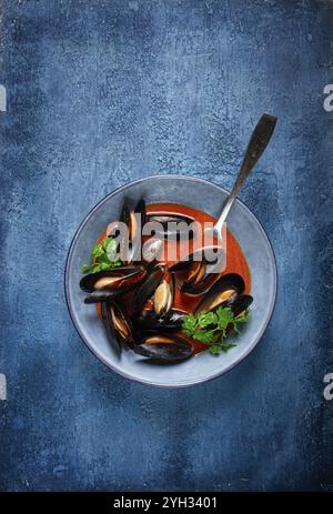 FRA Diavolo Muscheln, Muscheln in Tomatensauce, italienisches Gericht, auf blauem Hintergrund, hausgemacht, keine Leute Stockfoto