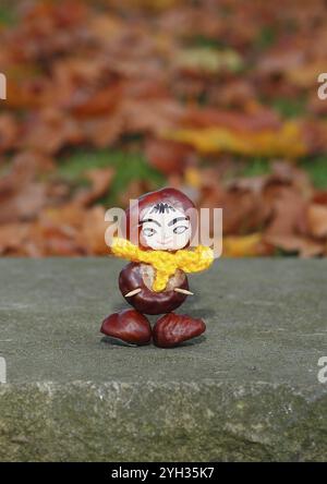 Lustige Kastanienfigur mit gelbem Schal an der Wand, Nordrhein-Westfalen, Deutschland, Europa Stockfoto