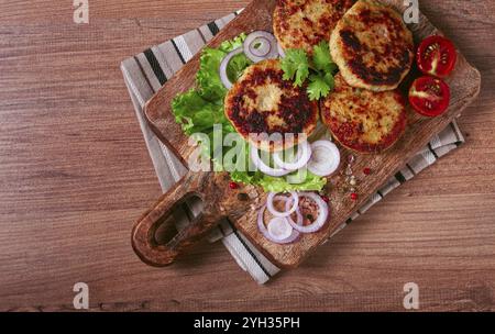 Gebratene Hähnchenkoteletts, gehacktes Huhn, mit Gemüse, auf einem Schneidebrett, mit Gemüsesalat, Blick von oben, hausgemacht, keine Leute Stockfoto