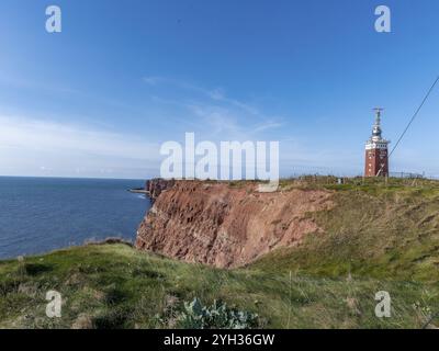 Helgoland Leuchtturm mit Radarantenne auf dem hügeligen Oberland der vorgelagerten Insel Helgoland und roter Sandsteinklippe, Helgoland, Nordsee Stockfoto