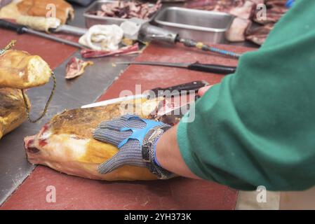 Nahaufnahme des Arbeitnehmers Hände im industriellen Prozess des Schneidens iberischen Schinken Stockfoto