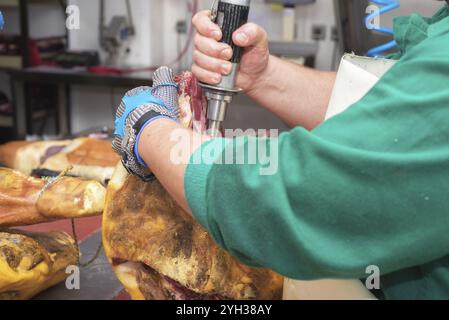 Nahaufnahme des Arbeitnehmers Hände im industriellen Prozess des Schneidens iberischen Schinken Stockfoto