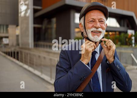 Porträt eines selbstbewussten älteren Mannes mit Fahrradhelm und einem Lächeln in die Kamera auf dem Weg zur Arbeit Stockfoto