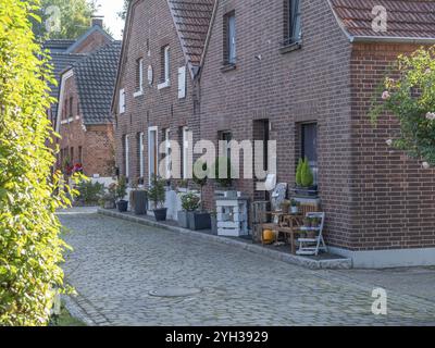 Terrassenhäuser im Backsteinstil mit Gartenmöbeln und Blumenschmuck in einer ruhigen Straße, Krudenburg, huenxe, Nordrhein-Westfalen, deutschland Stockfoto