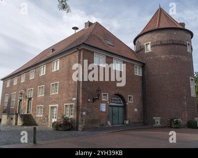 Altes Backsteinhaus mit rundem Turm und Treppen in ruhiger Nachbarschaft, Ramsdorf, münsterland, deutschland Stockfoto