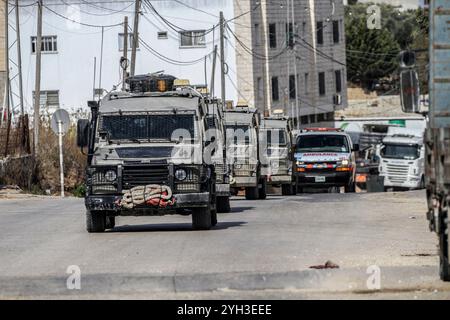 Jenin, Palästina. November 2024. Israelische Militärfahrzeuge umzingelten ein Haus, das von einem Palästinenser bewohnt wurde, und sperrten die Straße während eines Überfalls, um einen Palästinenser im Dorf Aqaba, südlich der Stadt Dschenin, im nördlichen Westjordanland, zu verhaften. Stundenlang brachen Zusammenstöße zwischen Palästinensern und israelischen Truppen aus, die zum Tod eines Palästinensers führten, dessen Leiche von der Armee festgenommen wurde, und zur Verletzung eines anderen bei einer Militäroperation der israelischen Streitkräfte. Quelle: SOPA Images Limited/Alamy Live News Stockfoto