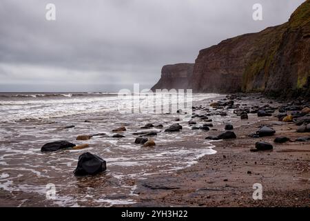 Raue See und felsiger Strand in Hunt Cliff, Saltburn, England. Stockfoto