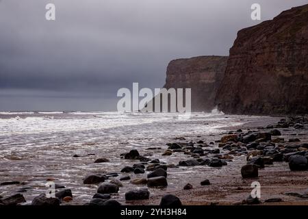 Raue See und felsiger Strand in Hunt Cliff, Saltburn, England. Stockfoto