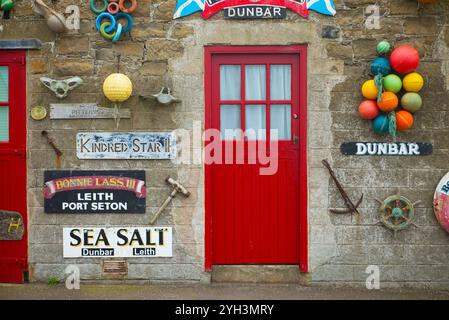 Mauer im Hafen von Dunbar mit Schildern von Fischerbooten Stockfoto