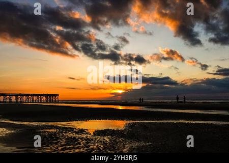 Isle Of Palms, Usa. November 2024. Touristen, die von Sonnenaufgang umgeben sind, stehen bei Ebbe auf einer Sandbank und beobachten den Sonnenaufgang über dem Atlantikhorizont am Front Beach, 9. November 2024 in Isle of Palms, South Carolina. Sonniges Wetter in den 70er Jahren wird für das niedere Land für die nächsten zehn Tage prognostiziert. Quelle: Richard Ellis/Richard Ellis/Alamy Live News Stockfoto