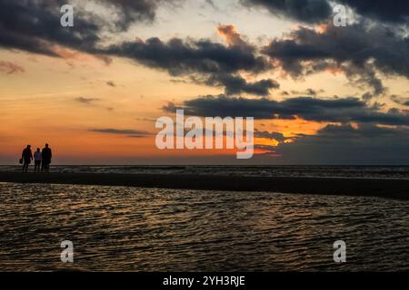 Isle Of Palms, Usa. November 2024. Touristen, die von Sonnenaufgang umgeben sind, stehen bei Ebbe auf einer Sandbank und beobachten den Sonnenaufgang über dem Atlantikhorizont am Front Beach, 9. November 2024 in Isle of Palms, South Carolina. Sonniges Wetter in den 70er Jahren wird für das niedere Land für die nächsten zehn Tage prognostiziert. Quelle: Richard Ellis/Richard Ellis/Alamy Live News Stockfoto