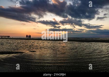 Isle Of Palms, Usa. November 2024. Touristen, die von Sonnenaufgang umgeben sind, stehen bei Ebbe auf einer Sandbank und beobachten den Sonnenaufgang über dem Atlantikhorizont am Front Beach, 9. November 2024 in Isle of Palms, South Carolina. Sonniges Wetter in den 70er Jahren wird für das niedere Land für die nächsten zehn Tage prognostiziert. Quelle: Richard Ellis/Richard Ellis/Alamy Live News Stockfoto