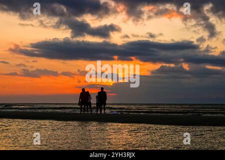 Isle Of Palms, Usa. November 2024. Touristen, die von Sonnenaufgang umgeben sind, stehen bei Ebbe auf einer Sandbank und beobachten den Sonnenaufgang über dem Atlantikhorizont am Front Beach, 9. November 2024 in Isle of Palms, South Carolina. Sonniges Wetter in den 70er Jahren wird für das niedere Land für die nächsten zehn Tage prognostiziert. Quelle: Richard Ellis/Richard Ellis/Alamy Live News Stockfoto