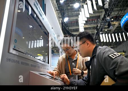 Shanghai. November 2024. Ein Mitarbeiter (L) stellt einem Besucher auf der Messe Trade in Services während der 7. China International Import Expo (CIIE) im ostchinesischen Shanghai am 9. November 2024 eine Plattform für Verkaufslösungen vor. Das Thema des Ausstellungsbereichs Handel mit Dienstleistungen, das sich auf die Digitalisierung konzentriert und den gesamten Lebenszyklus von Geschäftsaktivitäten konzentriert, stellt eine Integration von „grüner und kohlenstoffarmer Entwicklung, stabilen und starken Ketten und digitaler und intelligenter Zukunft“ dar. Quelle: Chen Haoming/Xinhua/Alamy Live News Stockfoto