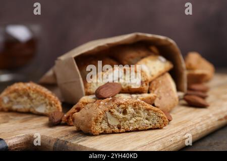 Leckere Mandelkekse (Cantuccini) und Nüsse auf Holztisch, Nahaufnahme Stockfoto