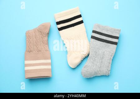Verschiedene bequeme Socken auf hellblauem Hintergrund, flach geschnitten Stockfoto