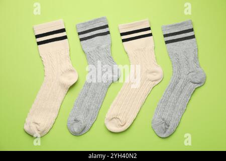 Verschiedene bequeme Socken auf hellgrünem Hintergrund, flach geschnitten Stockfoto