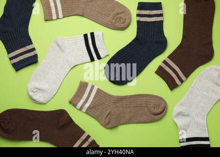 Verschiedene bequeme Socken auf hellgrünem Hintergrund, flach geschnitten Stockfoto