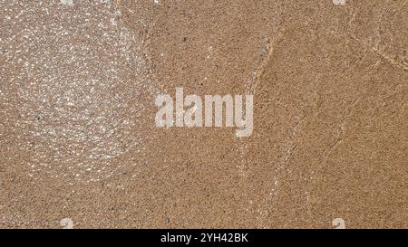 Seesand. Klares, durchsichtiges Wasser, Wellen an sonnigen Tagen mit viel Sand und Muscheln. Stockfoto