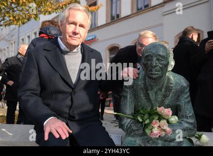 Chemnitz, Deutschland. November 2024. Christian Wulff, ehemaliger Bundespräsident, sitzt neben der Bronzeskulptur „Bank für Justin Sonder“ am Brühl. Justin Sonder, geboren 1925, erlebte die Pogromnacht am 9. November 1938 in Chemnitz und wurde 1943 nach Auschwitz deportiert. Er überlebte und kehrte 1945 in seine Heimatstadt zurück. Er kämpfte bis zu seinem Tod 2020 gegen den Antisemitismus. Am Samstag (09.11.2024) wurde auf Initiative einer breiten Allianz zu seiner Erinnerung ein Bronzeporträt von ihm enthüllt. Quelle: Sebastian Willnow/dpa/Alamy Live News Stockfoto