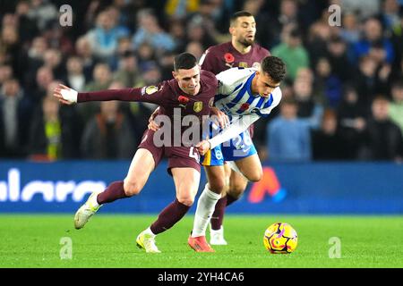 Phil Foden (links) von Manchester City und Yasin Ayari von Brighton und Hove Albion kämpfen um den Ball während des Premier League-Spiels im American Express Stadium in Brighton. Bilddatum: Samstag, 9. November 2024. Stockfoto