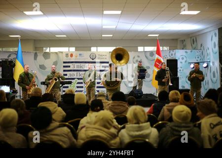 Odessa, Ukraine. November 2024. Zuschauer sehen die Auftritte von Musikern des Konzertorchesters der Odessa Military Academy, Brass Band „Guten Abend“ in der Lobby des Chornomorets Stadions. Aufführung von Musikern des Konzertorchesters der Odessa Military Academy, Brass Band „Guten Abend“ in der Lobby des Chornomorets Stadions. Ziel ist es, die Moral der Bevölkerung während der militärischen Aggression der Russischen Föderation zu unterstützen. Quelle: SOPA Images Limited/Alamy Live News Stockfoto