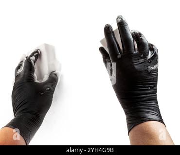 Hände in schwarzem Gummischutzhandschuh. Hände halten einen Schwamm im Schaum. Der Prozess des Geschirrspülens oder der Reinigung. Isoliert auf weiß Stockfoto