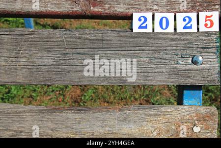 Zahlen von 2025 Jahren. Quadratische Zahlen aus Papier auf hölzernem Hintergrund, das bedeutet, dass Silvester kommt. Weihnachten, Feiertage, Festkonzept Stockfoto