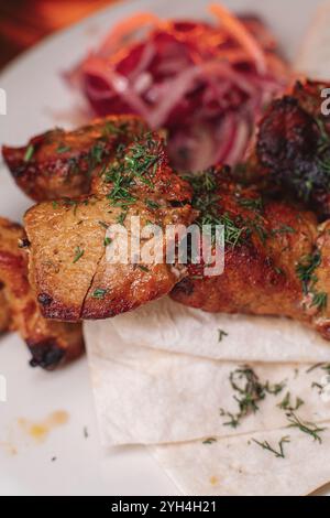 Schweinekebab auf einem Teller. Saftiges, köstliches Essen. Stockfoto