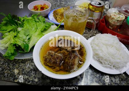 Hanoi, Vietnam - 8. Juli 2023: Bun Cha, ein vietnamesisches Gericht aus gegrilltem karamellisiertem Schweinefleisch, Nudeln und frischen Kräutern, wird im Bun Cha Huong Lien serviert. Stockfoto