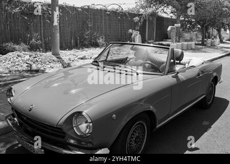 Mitzpe Ramon, Israel, 10. Mai 2024: Fiat 124 Sport Spider Cabriolet mit antikem Sammlerauto parkt auf einer Seitenstraße in Schwarz-weiß Stockfoto