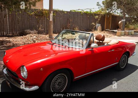 Mitzpe Ramon, Israel, 10. Mai 2024: Fiat 124 Sport Spider Red Cabriolet mit antikem Sammlerauto parkt auf einer Seitenstraße Stockfoto