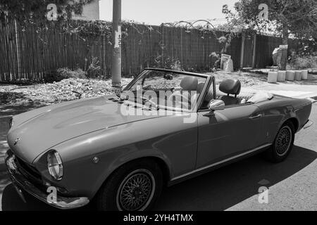 Mitzpe Ramon, Israel, 10. Mai 2024: Fiat 124 Sport Spider Cabriolet mit antikem Sammlerauto parkt auf einer Seitenstraße in Schwarz-weiß Stockfoto