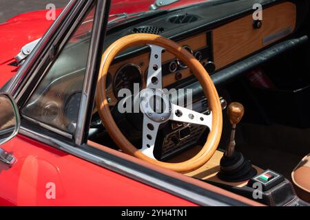 Mitzpe Ramon, Israel, 10. Mai 2024: Fiat 124 Sport Spider Holzlenkrad und Armaturenbrett-Nahaufnahme eines roten antiken Sammlerfahrzeugs Stockfoto