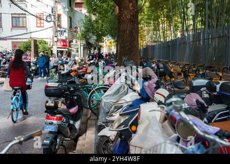 Belebte Straßenszene mit Radfahrern in Shanghai, China Stockfoto