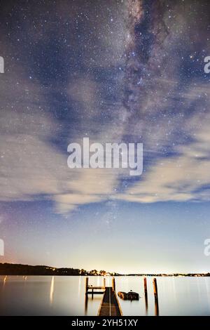 Milchstraße hinter verschwommenen Wolken über dem Lake Macquarie in Australien - Sternenhimmel. Stockfoto