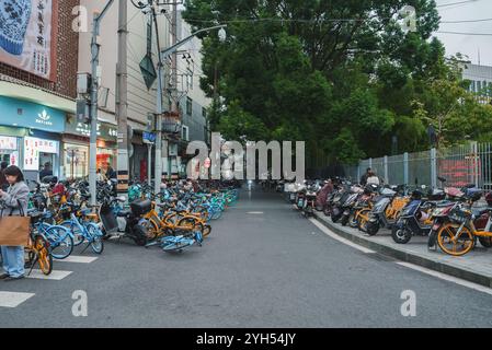 Geschäftige Straßenszene mit Fahrrädern und Motorrollern in Shanghai Stockfoto