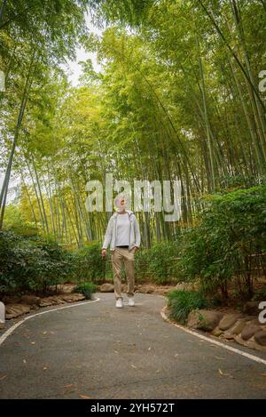 Mann auf dem Weg durch den dichten Bambuswald in der Nähe von Shanghai Stockfoto