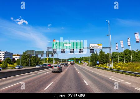 Autos auf der Autobahn unter klarem blauem Himmel, mit Straßenschildern in Richtung Sundsvall und Arlanda Airport. Schweden. Stockholm. Stockfoto