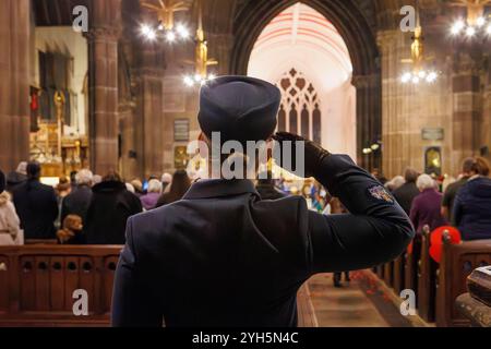 Warrington, Cheshire, England, Großbritannien. November 2024. Das jährliche Festival of Remembrance findet in der St. Elphin's Parish Church statt. Es war ein Abend, um an den Dienst und die Opfer unserer Streitkräfte in weltweiten Konflikten zu erinnern und zu ehren. Weibliche Offizierin grüßt die Gefallenen in den Kriegen. Quelle: John Hopkins/Alamy Live News Stockfoto