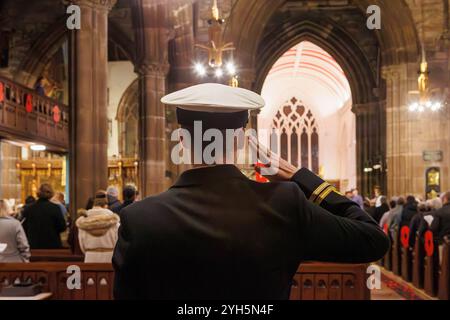 Warrington, Cheshire, England, Großbritannien. November 2024. Das jährliche Festival of Remembrance findet in der St. Elphin's Parish Church statt. Es war ein Abend, um an den Dienst und die Opfer unserer Streitkräfte in weltweiten Konflikten zu erinnern und zu ehren. Offizier grüßt in Respekt für die Gefallenen. Quelle: John Hopkins/Alamy Live News Stockfoto