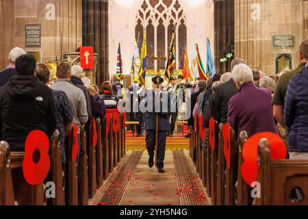 Warrington, Cheshire, England, Großbritannien. November 2024. Das jährliche Festival of Remembrance findet in der St. Elphin's Parish Church statt. Es war ein Abend, um an den Dienst und die Opfer unserer Streitkräfte in weltweiten Konflikten zu erinnern und zu ehren. Flight Lieutenant Alan Radcliffe, Offizier der 1330. Squadron trägt das Kruzifix am Mittelschiff entlang und führt die Parade der Standards aus der Kirche. Quelle: John Hopkins/Alamy Live News Stockfoto