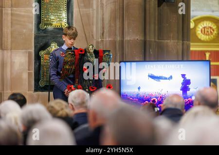 Warrington, Cheshire, England, Großbritannien. November 2024. Das jährliche Festival of Remembrance findet in der St. Elphin's Parish Church statt. Es war ein Abend, um an den Dienst und die Opfer unserer Streitkräfte in weltweiten Konflikten zu erinnern und zu ehren. Ein Junge der Royal Air Force Air Cadets 1330 (Warrington) Squadron rezitiert von der Kanzel aus mit einem Erinnerungsschirm neben ihm. Quelle: John Hopkins/Alamy Live News Stockfoto