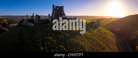 Blick auf den Sonnenuntergang von Corfe Castle aus der Luft, einem Dorf und einer Zivilpfarrei in der englischen Grafschaft Dorset Stockfoto